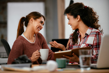 Two women working together.  Beautiful colleagues working on project. 