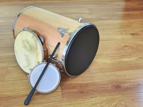 Three Brazilian percussion musical instruments: &ldquo;tantan&rdquo; (or &ldquo;rebolo&rdquo;), pandeiro (tambourine) and tamborim with drumstick, on a wooden surface. They are widely used in samba and pagode ensembles.