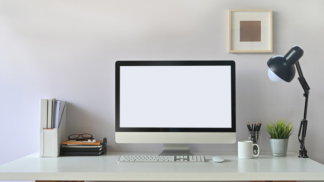 Photo of white blank screen computer  and office equipment is on the table. Modern working desk concept.