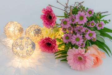 Flowers on a white surface with romantic lights