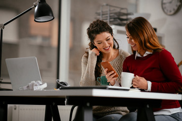 Colleagues chatting in office. Two beautiful businesswomen at work. 
