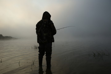 silhouette of fisherman in fog with copy space