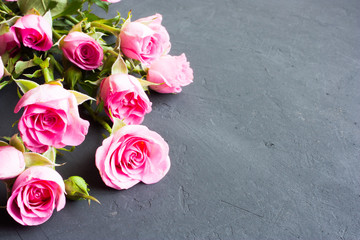 bouquet of small pink roses on a dark gray background on concrete. Valentine's day composition, selective focus.