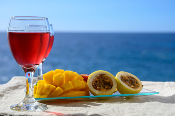 Two glasses with rose wine served outdoor with exotic fruits on tropical island La Palma, Canary islands, Spain with beautiful blue ocean view