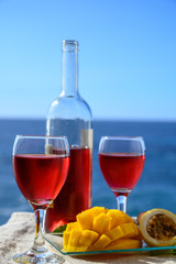 Two glasses with rose wine served outdoor with exotic fruits on tropical island La Palma, Canary islands, Spain with beautiful blue ocean view