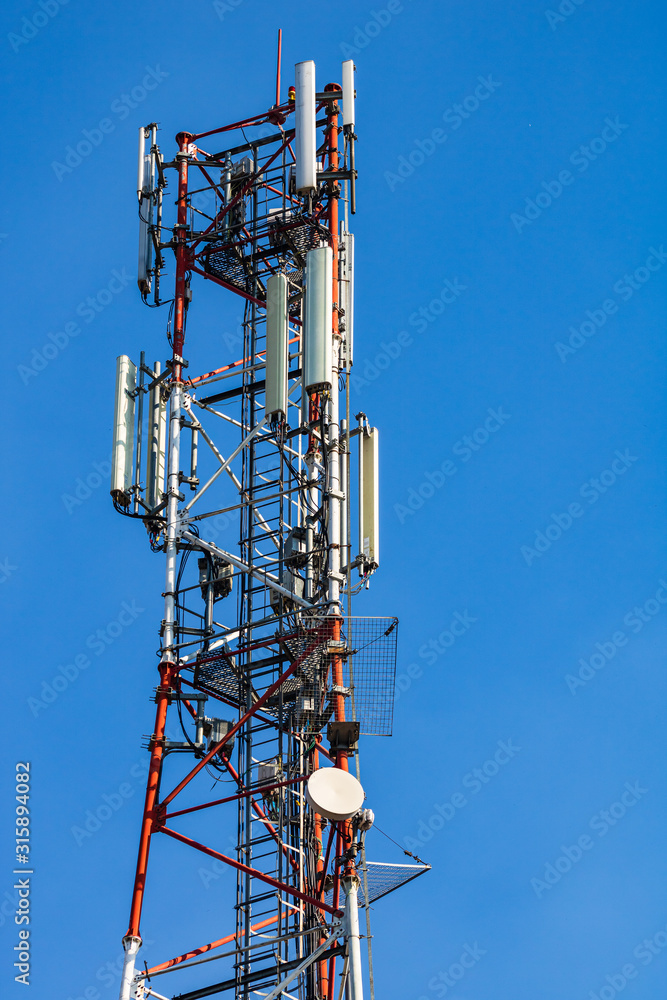 Wall mural high voltage post. high voltage tower on blue, clear sky.