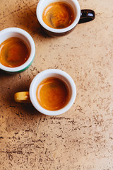 Three color coffee cups on light background copy space