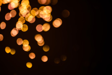 Golden sparkles raster festive background. Bokeh lights with bright shiny effect illustration. Overlapping glowing and twinkling spots decorative backdrop. Abstract glittering circles