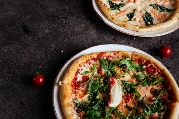 Traditional Italian pizza on a dark background top view copy space.