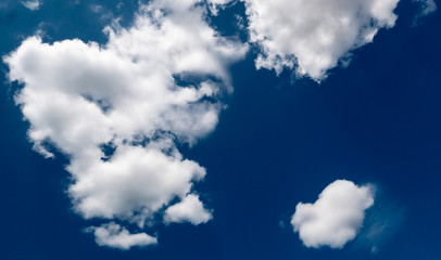 white dramatic clouds floating in the blue sky
