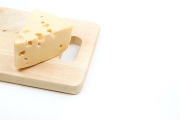 piece of cheese with holes on a cutting board on a white background with copy space