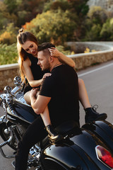 Fototapeta na wymiar Couple of lovers kissing and hugging on motorbike - Two bikers stop in the countryside