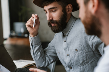 Image of caucasian young businesslike men working together at office