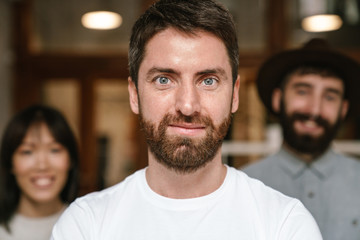 Image of multiethnic young business workers standing together at office
