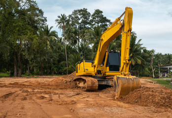 Yellow excavator on a construction site against blue sky. Heavy industry. Close up details of...