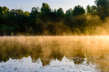 Fog above the water surface. Sunrise at river