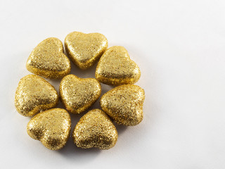Golden glitter covered hearts on white background. Saint Valentine and love theme.