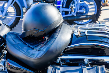 Closeup of the helmet on seat of classical cruiser or chopper motorcycle. Safety riding concept