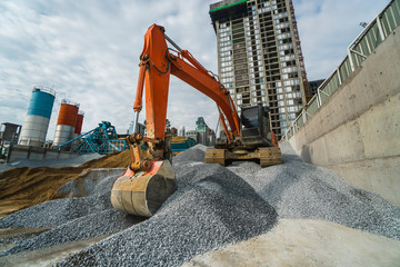Large orange excavator working on a gravel on construction site. Details of industrial excavator....