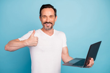 Close-up portrait of nice attractive cheerful cheery guy IT programmer geek holding in hands laptop...