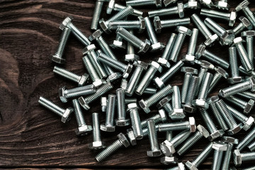 Pile of bolts on wooden background..pile of bolts on wooden background.