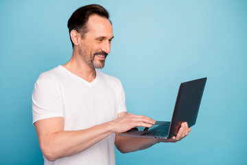 Close-up portrait of his he nice attractive cheerful cheery guy IT tech support geek using laptop remote qualification isolated on bright vivid shine vibrant teal green blue turquoise color background