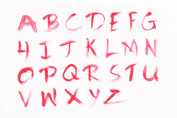 Letters A-Z with red watercolor on white paper background. Handwritten alphabet.