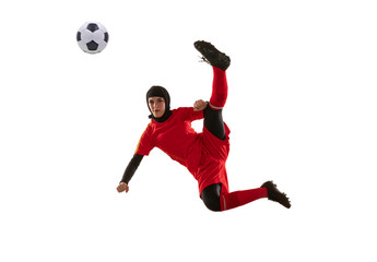 Fototapeta na wymiar Arabian female soccer or football player isolated on white studio background. Young woman kicking ball in jump, catched in air, training in motion, action. Concept of sport, hobby, healthy lifestyle.