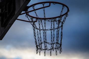 Streetball basketball basket with chains in the place of net, on a dark day