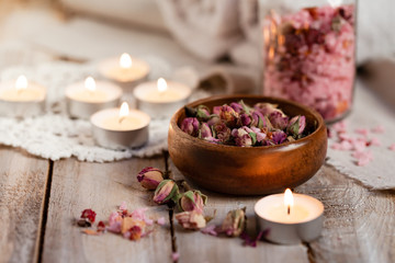 Concept of spa treatment with roses. Dry flowers in a bowl, crystals of sea pink salt in bottle, candles as decor. Atmosphere of relax, anti-stress and detox prosedure. Luxury lifestyle. 