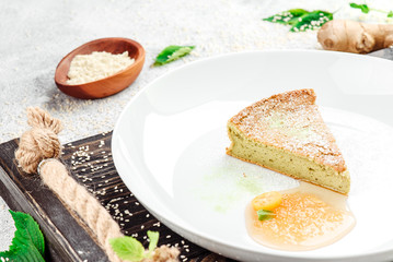 Sugar-free and gluten-free casserole with agave syrup on beautiful white plate on dark rustic tray on light concrete background in beautiful composition. Close-up. Space