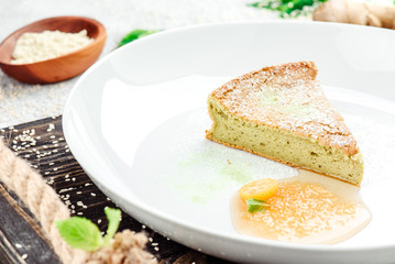 Sugar-free and gluten-free casserole with agave syrup on beautiful white plate on dark rustic tray on light concrete background in beautiful composition. Close-up. Space