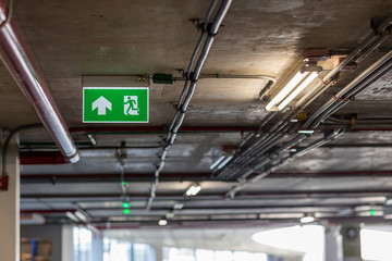 Green emergency exit sign showing the way to escape.Fire exit in the building.