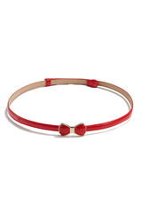 Fototapeta premium Subject shot of a thin belt made of red patent leather and decorated with a figured buckle in the form of a red enamel bow-knot in golden setting. The stylish belt is isolated on the white background.