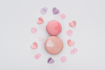top view of pink macarons and violet hearts isolated on white