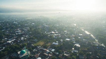 Fototapeta na wymiar Residential neighborhood subdivision skyline Aerial shot. Top view of house Village from Drone capture. Top-down aerial drone image of a suburb in the midst of summer. Midtown of Indonesia.