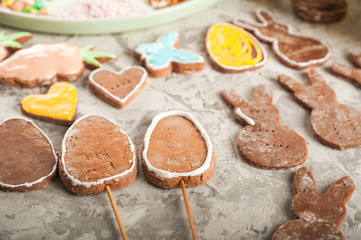 The process of painting gingerbread with glaze. Flat lay cookie eggs. Handpainted gingerbread bunnies and eggs for Easter and copy space.