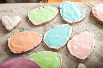 The process of painting gingerbread with glaze. Flat lay cookie eggs. Handpainted gingerbread bunnies and eggs for Easter and copy space.