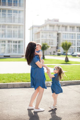 young mother and daughters outdoor. Happy family. 