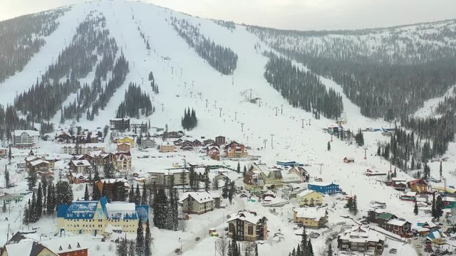 Mounting skiing resort. People skiing and snowboarding from the mountain.Beautiful view from above