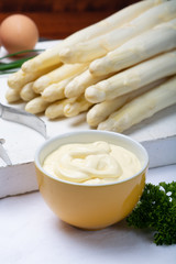 White hollandaise sauce in bowl, traditional sauce for dishes with cooked white asparagus
