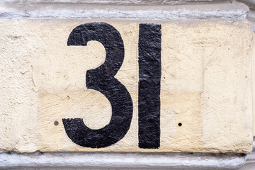 Number 31, thirty one, street number sign on the wall	