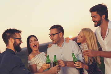 Friends drinking beer at an outdoor summertime party