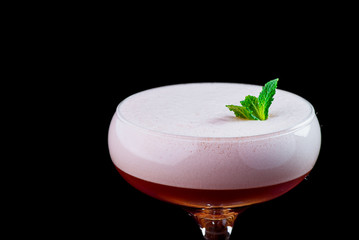 Elegant red ladies' cocktail with pink foam in a beautiful glass on a wooden carved round board
