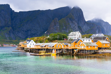 Famous tourist attraction Hamnoy fishing village on Lofoten Islands, Norway with red and yellow rorbu houses. Calm, blurred water © Milosz Maslanka