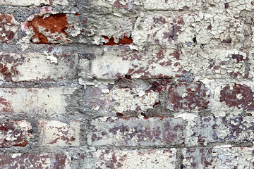 white pealing paint red brick wall