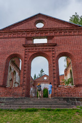 Tourists exploring ruined Lutheran church in Lahdenpohja, Karelia, Russia. Destroyed protestant temple. Architectural landmark in northern Russian town with Finnish heritage