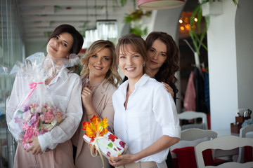 Group of female people meets in cafe to  congratulate the  birthday girl and celebrate the   holiday. Girlfrieng hug