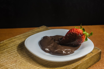 postre fresa con chocolate en plato blanco