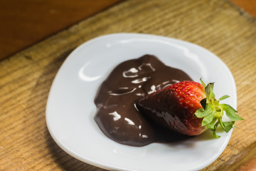 postre fresa con chocolate en plato blanco